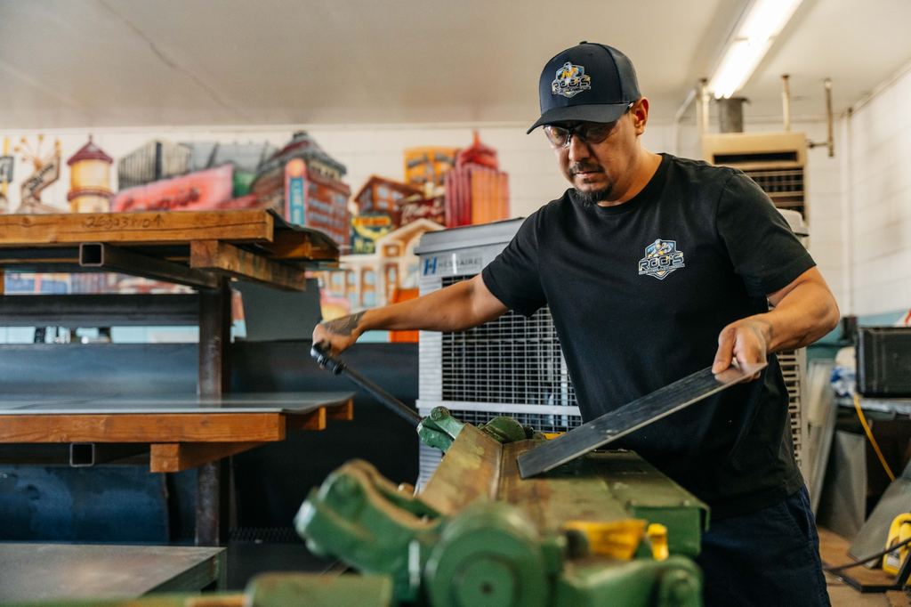 Fabricator forming a steel strip on a shop brake