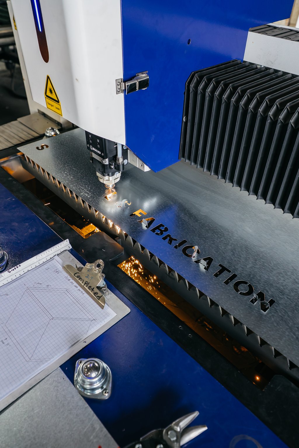 CNC laser head cutting a metal part in the Fresno shop