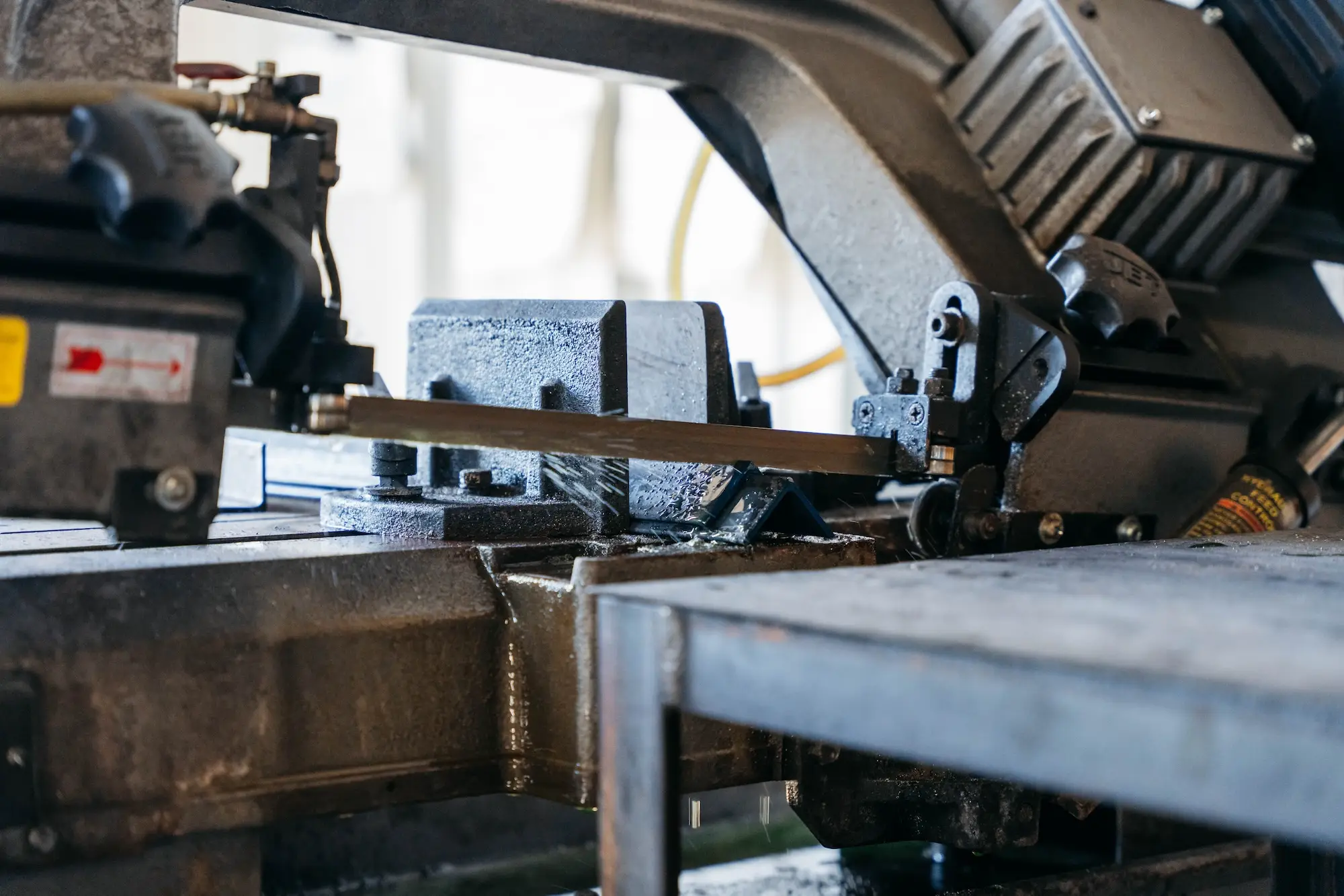 Bandsaw cutting steel stock for a machinery bracket